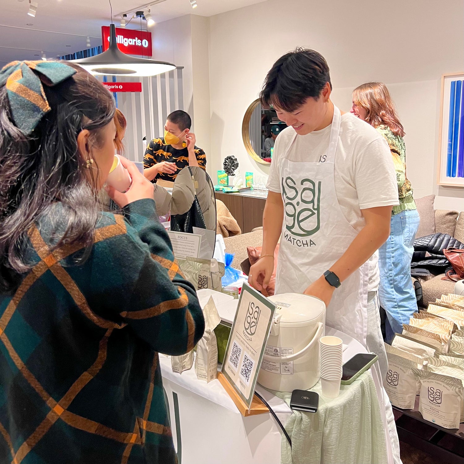 Holiday Market. Larry, founder of Sage Matcha, smiling, preparing free sample of Sage Matcha. 